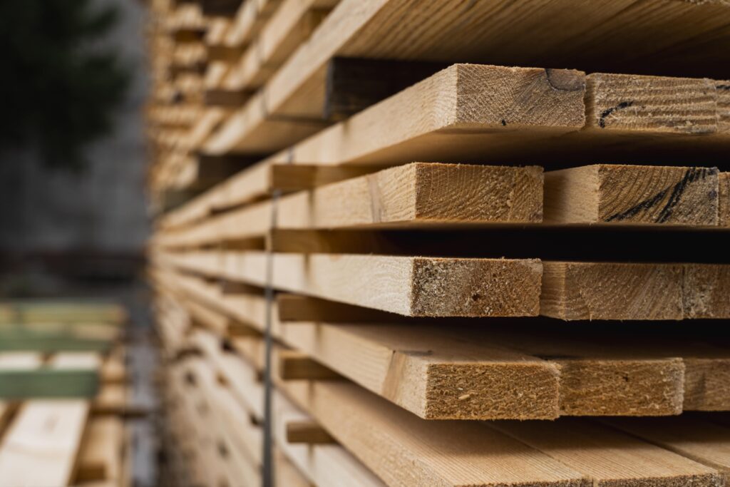 Das Foto zeigt eine Nachaufnahme von mehreren, neuen, übereinander gestapelten Holzbrettern zur Weiterverarbeitung.